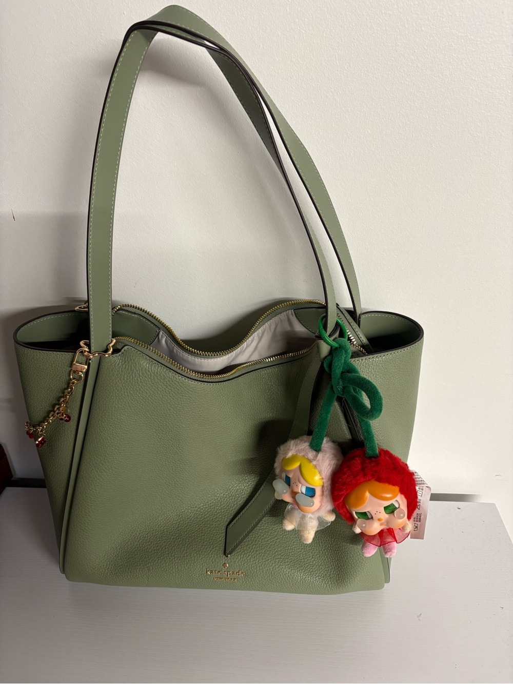 kate spade sage green leather tote with playful charm